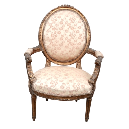 654 - A Louis XVI style open armchair, fauteuille a medallion, 20th century, carved and gilded frame, with... 