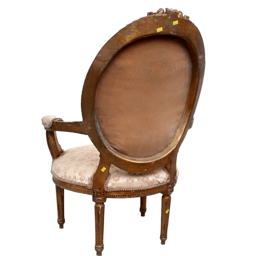 654 - A Louis XVI style open armchair, fauteuille a medallion, 20th century, carved and gilded frame, with... 