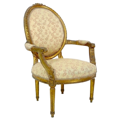 654 - A Louis XVI style open armchair, fauteuille a medallion, 20th century, carved and gilded frame, with... 