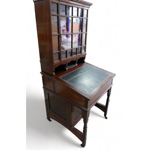 634 - An early 1900s mahogany davenport bookcase with a glazed bookcase top above a leather inset slope an... 