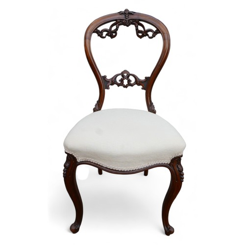 611 - A set of six Victorian dining chairs, the balloon back and middle rail carved with foliage scrolls, ... 