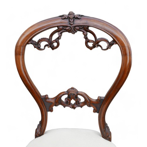 611 - A set of six Victorian dining chairs, the balloon back and middle rail carved with foliage scrolls, ... 