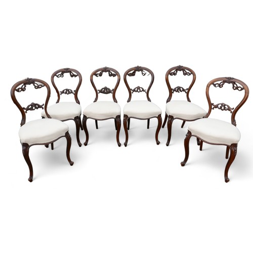 611 - A set of six Victorian dining chairs, the balloon back and middle rail carved with foliage scrolls, ... 