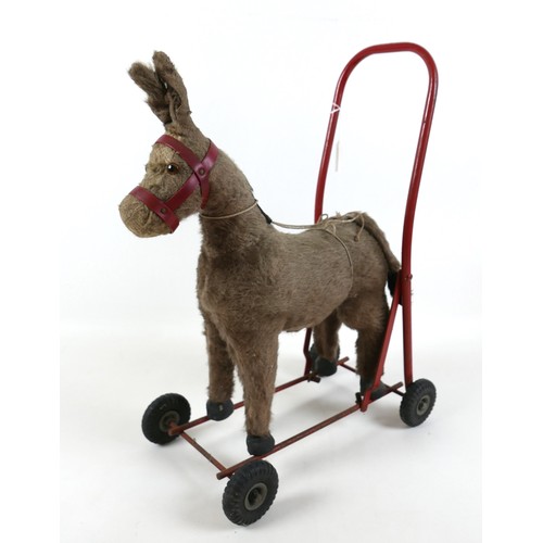 188 - A group of toys, comprising an International Aircraft Co Ltd. push along donkey, 53cm high, a plasti... 