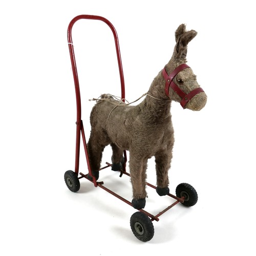 188 - A group of toys, comprising an International Aircraft Co Ltd. push along donkey, 53cm high, a plasti... 