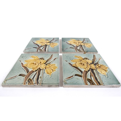 75 - A set of four Art Nouveau tiles, by Henry Abraham Ollivant, each decorated with a daffodil, 15.5 by ... 