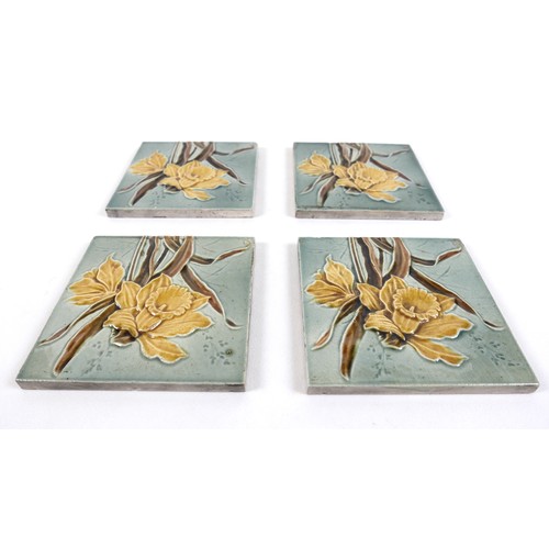 75 - A set of four Art Nouveau tiles, by Henry Abraham Ollivant, each decorated with a daffodil, 15.5 by ... 