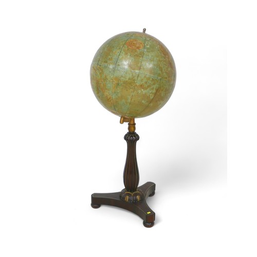 640 - A Philips 19 inch library globe on a mahogany tripartite platform stand, 48 by 108cm tall.