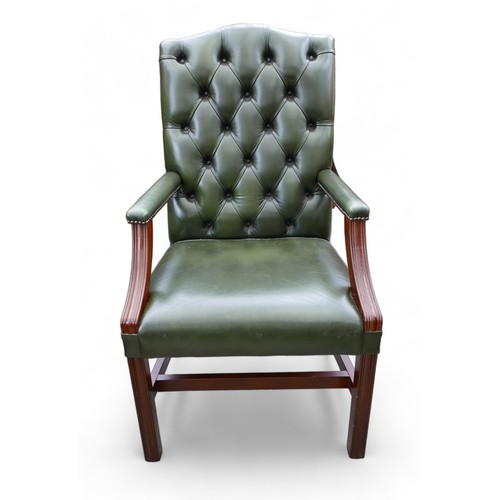 614 - A modern green leather button back library open armchair, 61 by 60 by 108cm.