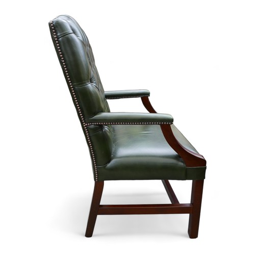 614 - A modern green leather button back library open armchair, 61 by 60 by 108cm.