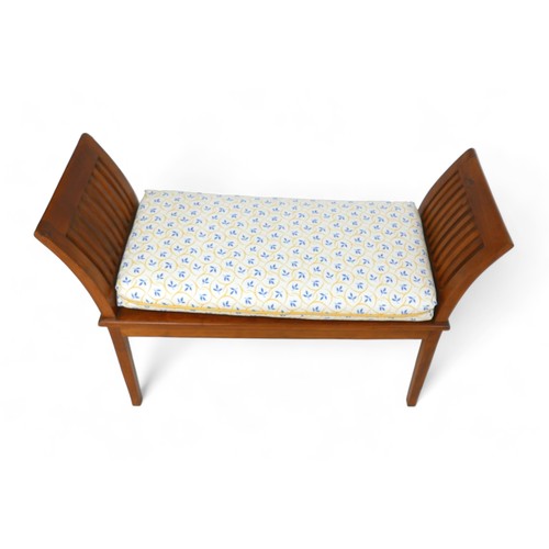 598 - An open wooden bench, with exaggerated sides, on straight legs, with a cream and blue upholstered cu... 