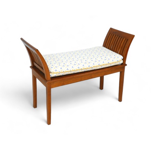 598 - An open wooden bench, with exaggerated sides, on straight legs, with a cream and blue upholstered cu... 