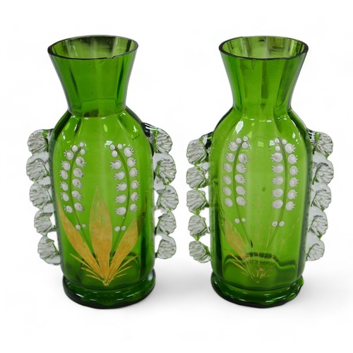 61 - A pair of Victorian green glass vases, in Mary Gregory style, decorated with Lily of the Valley. (2)