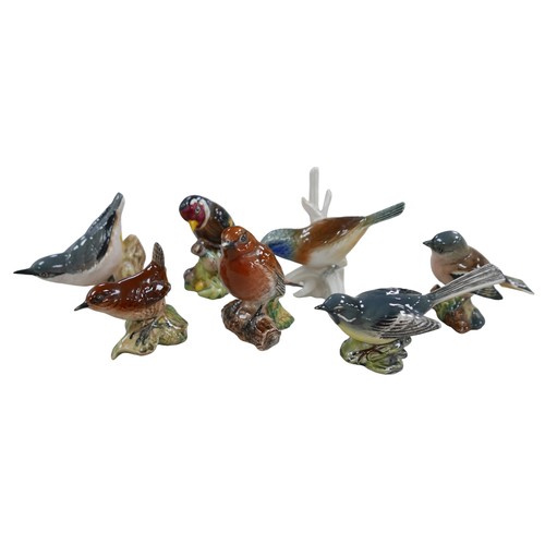 62 - A group of seven small bird figurines, six Beswick plus one Karl Ens on a branch. (7)