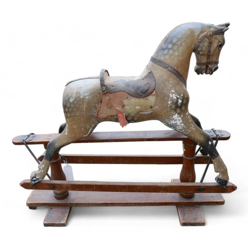 140 - An Edwardian rocking horse, dapple grey with part leather saddle and red cloth sides, a/f missing sa... 