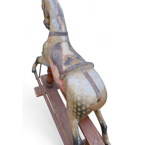 140 - An Edwardian rocking horse, dapple grey with part leather saddle and red cloth sides, a/f missing sa... 