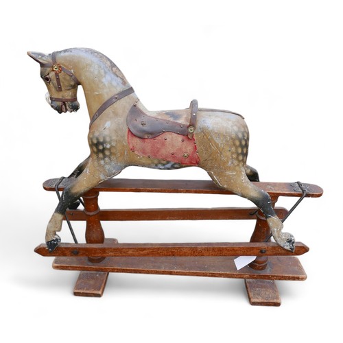 140 - An Edwardian rocking horse, dapple grey with part leather saddle and red cloth sides, a/f missing sa... 