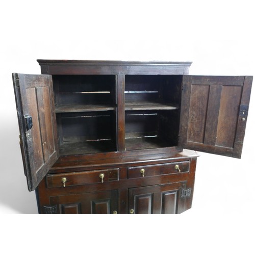 631 - A 17th century oak cupboard, with two doors, two drawers, and two cupboards below, in two sections, ... 