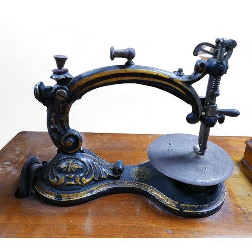 141 - A Victorian 'W. Taylor's Patent' bow arm sewing machine, with mahogany top and original accessories.