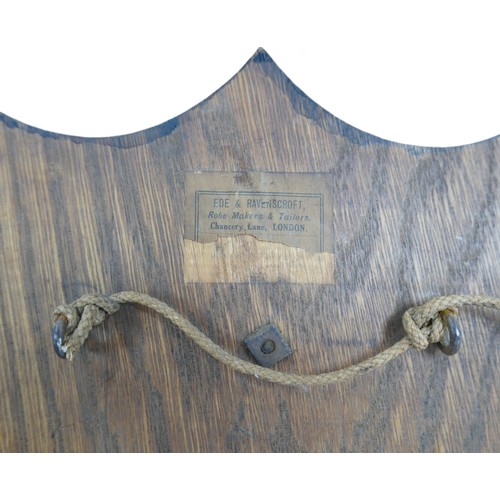 120 - A college library shield on an oak mount, 24cm by 31cm. Ede and Ravenscroft part label verso.