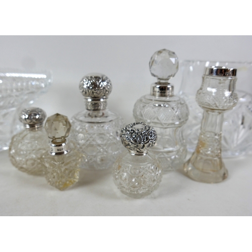 110A - A group of silver topped cut glass bottles, three ovoid with silver tops, two and a vase with silver... 