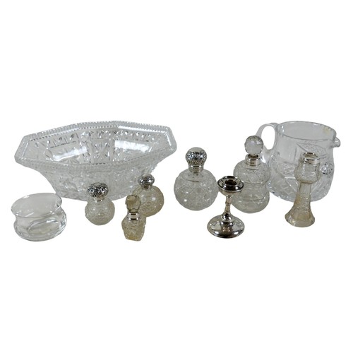 110A - A group of silver topped cut glass bottles, three ovoid with silver tops, two and a vase with silver... 