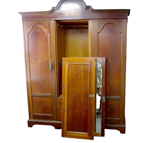 603 - An Edwardian mahogany triple wardrobe, in three sections with unusual triptych tilting central mirro... 