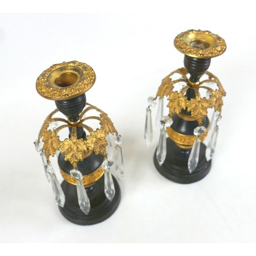 131A - A pair of 19th century bronze and gilt metal candlesticks, removable drip trays above a collar of ei... 