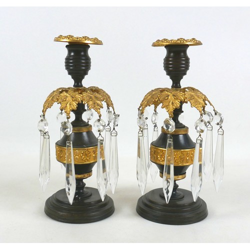 131A - A pair of 19th century bronze and gilt metal candlesticks, removable drip trays above a collar of ei... 