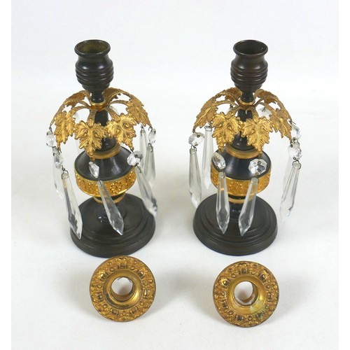 131A - A pair of 19th century bronze and gilt metal candlesticks, removable drip trays above a collar of ei... 