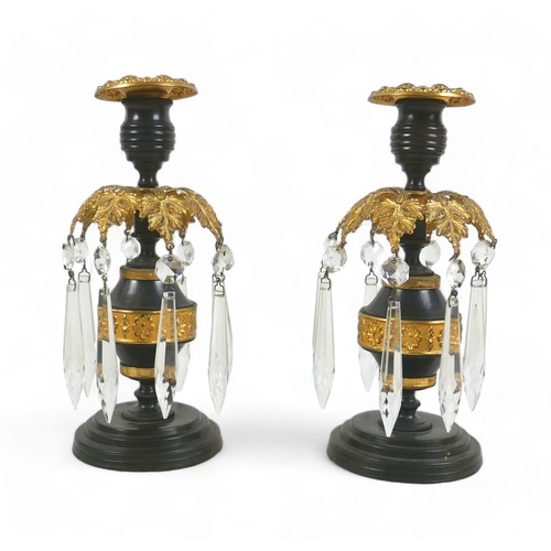 131A - A pair of 19th century bronze and gilt metal candlesticks, removable drip trays above a collar of ei... 