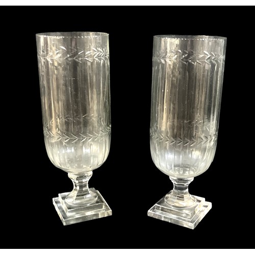 108 - A pair of Victorian tall, clear glass vases, wheel engraved with leaf rim, raised on a column and sq... 