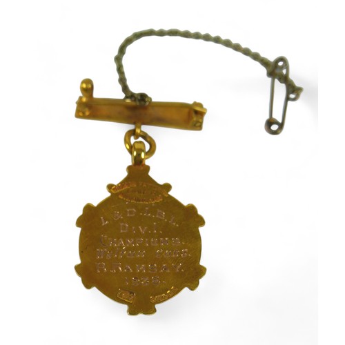 131 - A 9ct gold presentation medal, on yellow metal pin with safety chain, gross weight 7.4g.