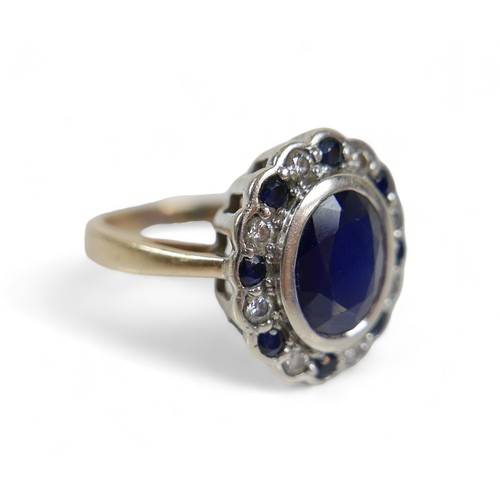 226 - A 9ct yellow and white gold cluster ring, set with one central oval cut sapphire, approx 3.03ct, sur... 