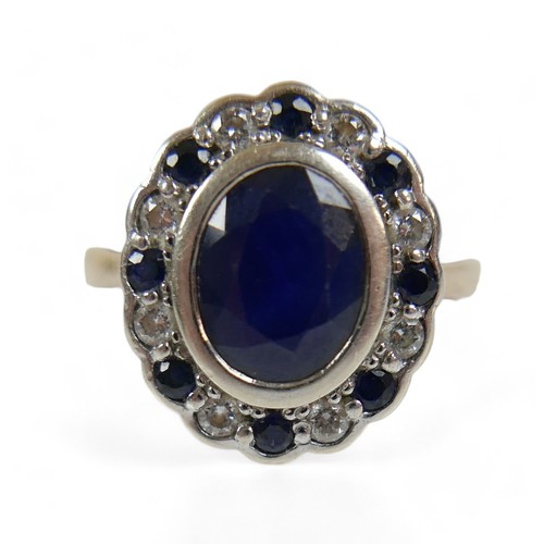 226 - A 9ct yellow and white gold cluster ring, set with one central oval cut sapphire, approx 3.03ct, sur... 