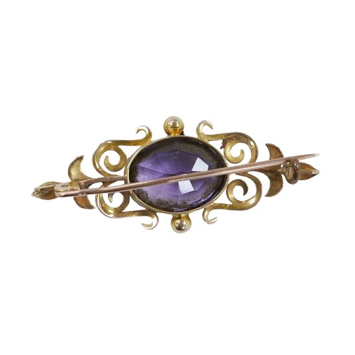 129 - A yellow metal and amethyst bar brooch, the oval cut stone, 16 by 13mm, 7.8g, with fitted case.