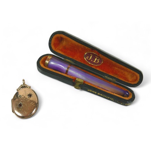 126 - A mother of pearl 9ct banded cigarette holder and a 9ct locket, the holder hallmarked Birmingham 191... 