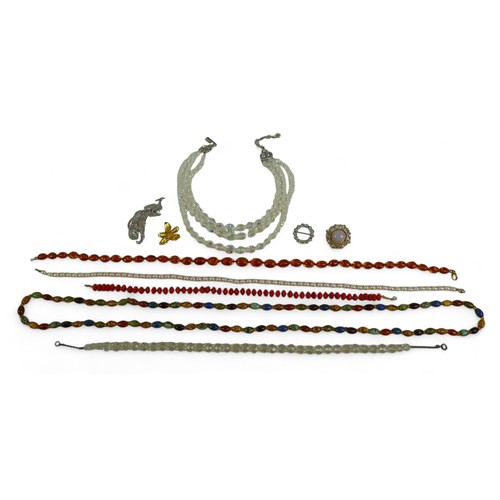 115 - A collection of costume jewellery, comprising brooches and necklaces, including an amber bead neckla... 