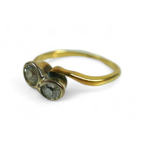 214 - An 18ct yellow gold ring, set with two brilliant cut diamonds, each 3.5mm, 0.17ct, in crossover sett... 