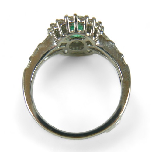 229 - A diamond and oval emerald ring, on unmarked white gold band (testing as minimum of 14k, probably 18... 