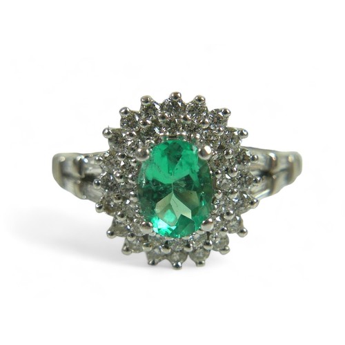 229 - A diamond and oval emerald ring, on unmarked white gold band (testing as minimum of 14k, probably 18... 