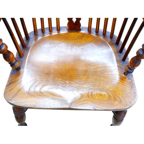 559 - An early 20th century Windsor chair, with high round back, elm seat, turned legs with crinoline stre... 