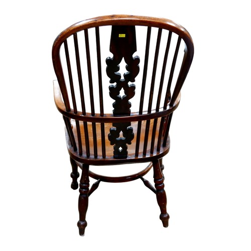 559 - An early 20th century Windsor chair, with high round back, elm seat, turned legs with crinoline stre... 