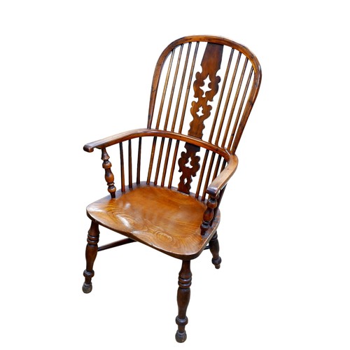 559 - An early 20th century Windsor chair, with high round back, elm seat, turned legs with crinoline stre... 