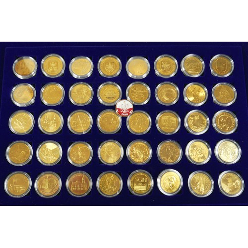 114 - Three coin cases, containing one hundred gilt world metal coins, case size 38 by 3 by 26cm. (3)