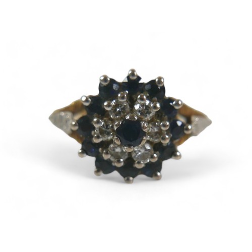 81 - A 15ct gold, diamond and sapphire flowerhead ring, with central sapphire, six diamonds and outer rin... 