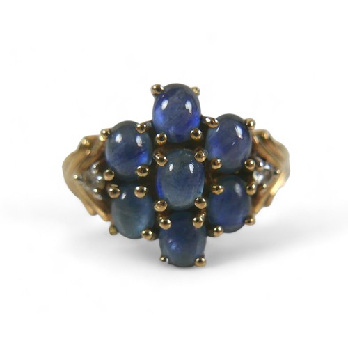 70 - A 9ct gold, diamond and blue cabochon stone ring, a central flowerhead of seven blue stones, with a ... 