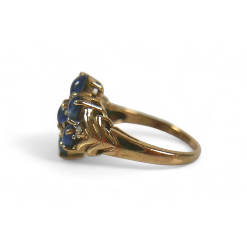 70 - A 9ct gold, diamond and blue cabochon stone ring, a central flowerhead of seven blue stones, with a ... 