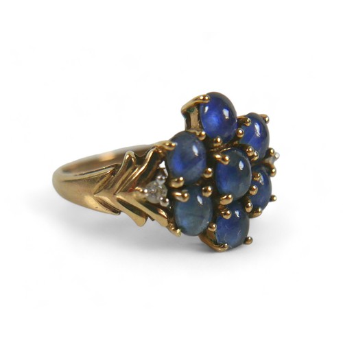 70 - A 9ct gold, diamond and blue cabochon stone ring, a central flowerhead of seven blue stones, with a ... 