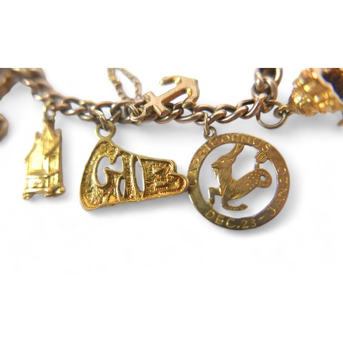 86 - A 9ct gold charm bracelet, with push clasp and safety chain, fourteen gold charms, including a horse... 